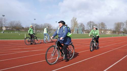 Woman cycling on athletics track at Thornes Park Stadium, Wakefield