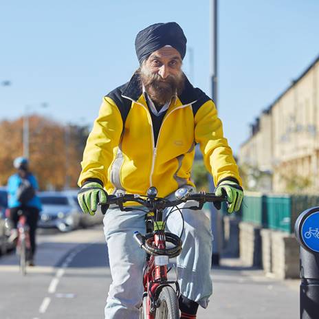 Man in turban cycling on segregated route