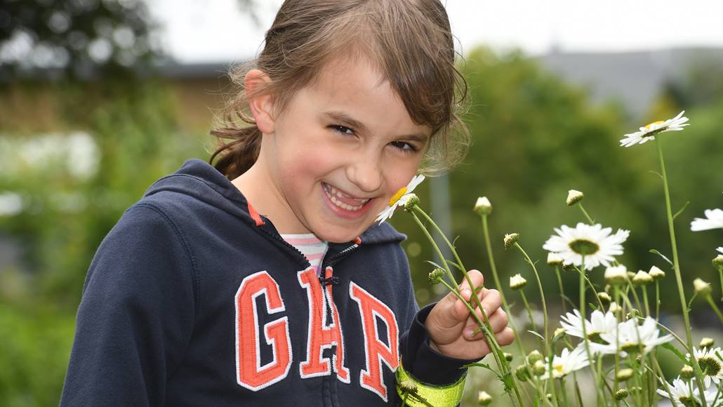 Young girl smiling with a flower on the canal
