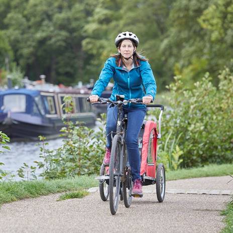 Woman cycling on canal towpath